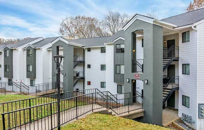 A row of white houses with black railings and steps leading to the doors.