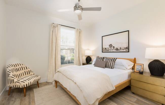 a bedroom with a bed and a chair and a ceiling fan