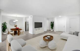 a living room with white furniture and a television