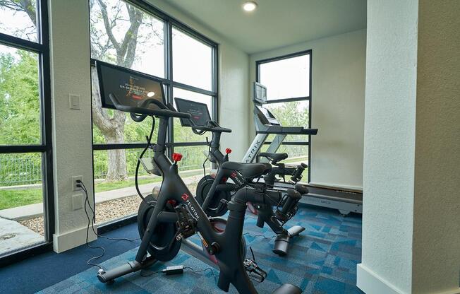 A room with a treadmill and a stationary bike.