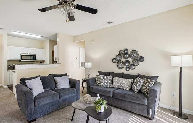 A living room with two couches and a ceiling fan.