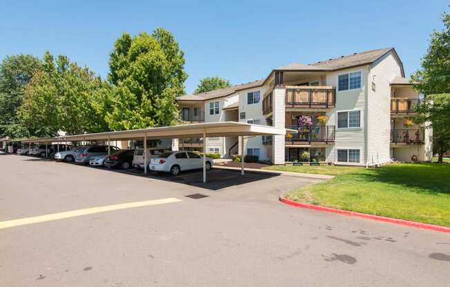 a parking lot with cars in front of an apartment building