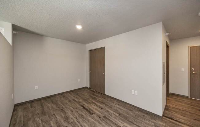 A room with wooden floors and two brown doors.