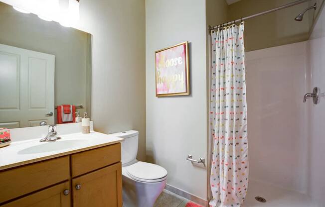A bathroom with a toilet, sink, and shower.