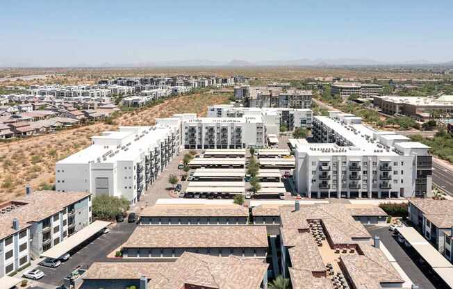 a cityscape of white buildings with a desert in the background