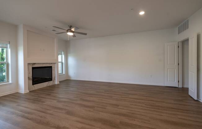 a living room with a fireplace and a ceiling fan at The Clearing at ONE28, Kansas