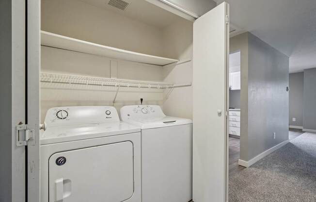 A white dryer and washer are in a small laundry room.
