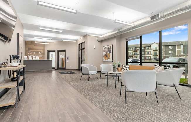 A spacious waiting area with white chairs and a wooden floor.
