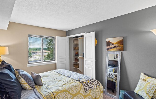 a bedroom with a bed and a door to a closet