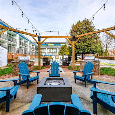 a patio with blue chairs and a fire pit