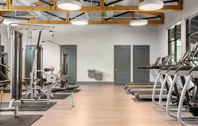 A gym with a variety of equipment including treadmills, weights, and exercise machines.