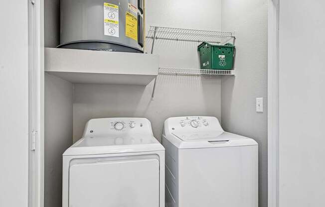 Two white front loading washing machines in a laundry room.