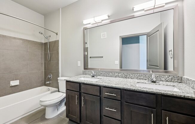A bathroom with a white toilet and a white bathtub.