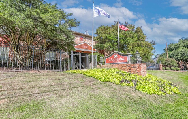 A sign that says "Magnolia" in front of the leasing office at Magnolia Apartments in Shreveport, LA