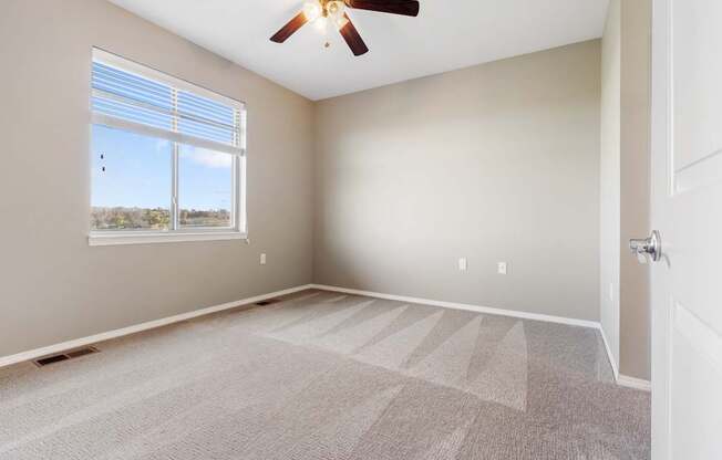 A room with a ceiling fan and a carpeted floor.