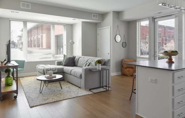 A modern living room with a grey couch and a white coffee table.