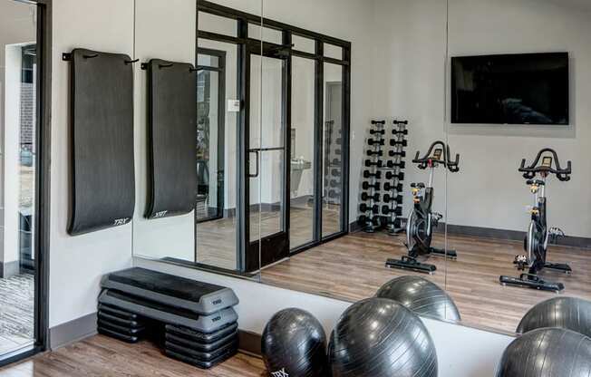 a gym with exercise equipment and mirrors on the wall