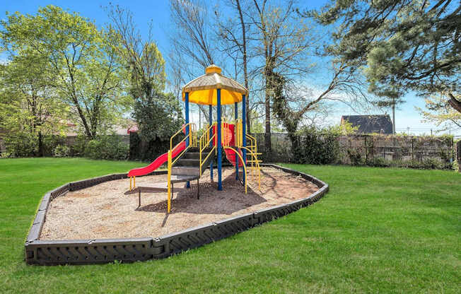 A playground with a yellow and red slide and a yellow and blue tower at Highland Ridge Apartments, Capitol Heights, MD