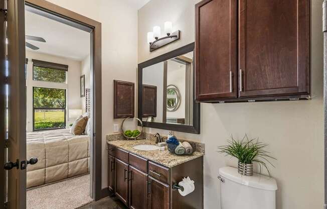 A bathroom with a brown vanity and a white toilet.