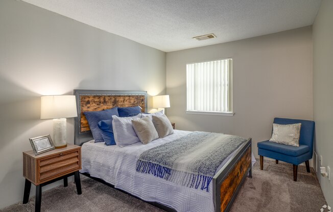 the master bedroom has a king sized bed with blue pillows