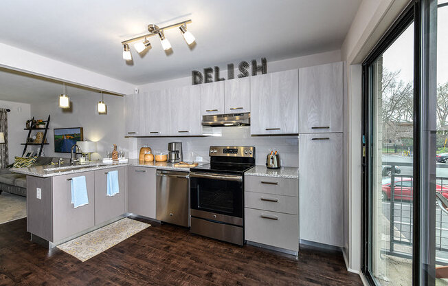 A kitchen with the word DELISH on the wall.