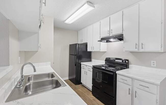 B1 kitchen with black appliances and white cabinets at Estelle Creek North Apartments in Irving, TX