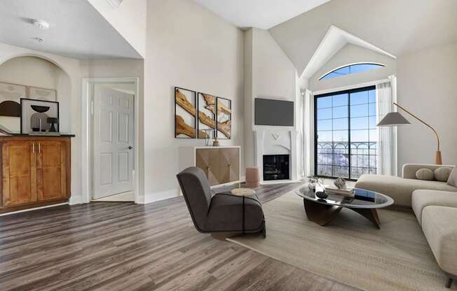 A modern living room with a large window and a wooden floor.
