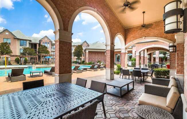 a patio with tables and chairs and a pool