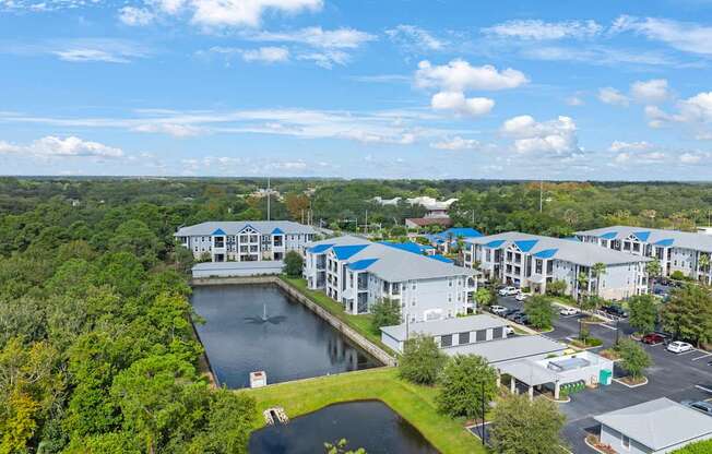 an aerial view of a resort with a lake and buildings
