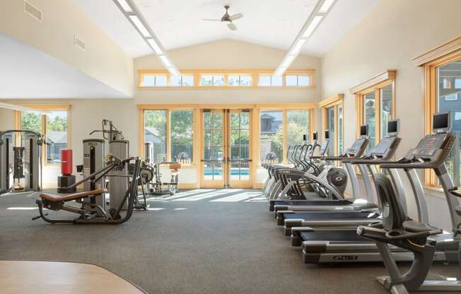the gym has plenty of cardio equipment and glass doors to the pool