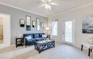 A living room with a blue couch and a white coffee table.