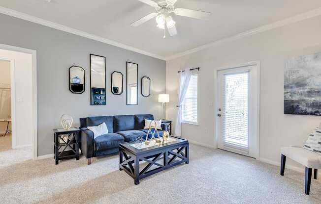 A living room with a blue couch and a white coffee table.