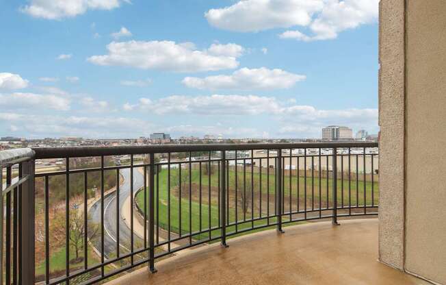 A balcony with a metal railing overlooks a baseball field.