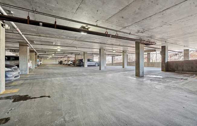 A large, empty parking garage with concrete pillars and floors.