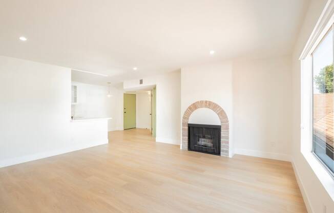 a living room with a fireplace and wooden floors