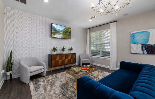 a living room with a blue couch and two chairs