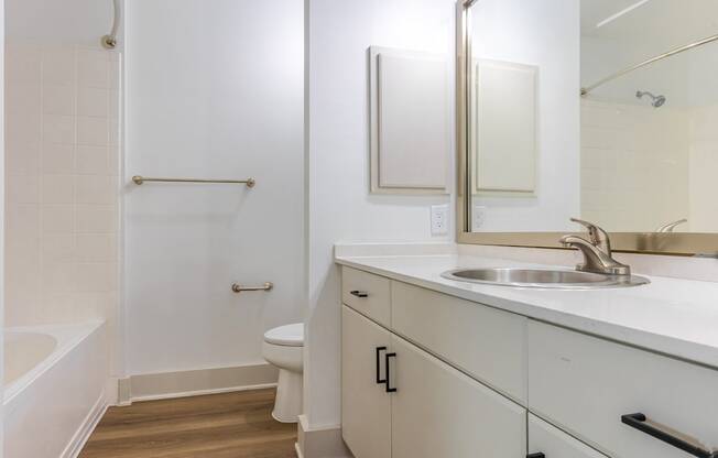A white bathroom with a toilet, sink, and bathtub.