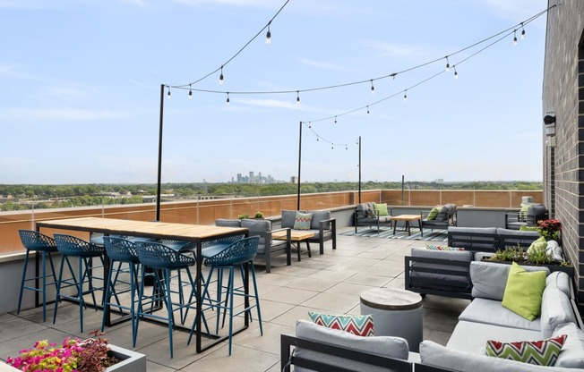 a rooftop patio with tables and chairs and a view of the city