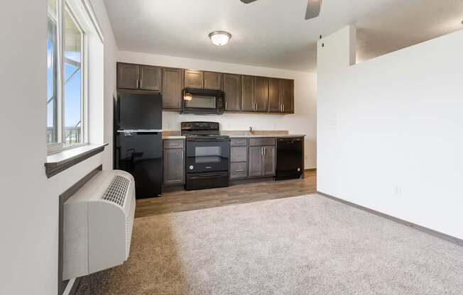 A kitchen with black appliances and brown cabinets.