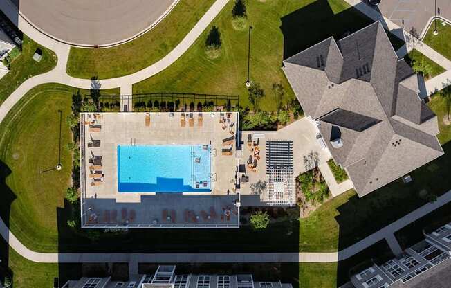 An aerial view of a building with a pool in front of it.