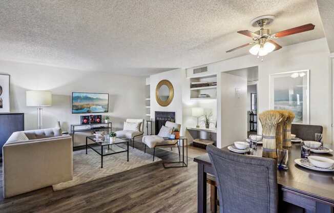 A well-lit living room with a dining area in the background.