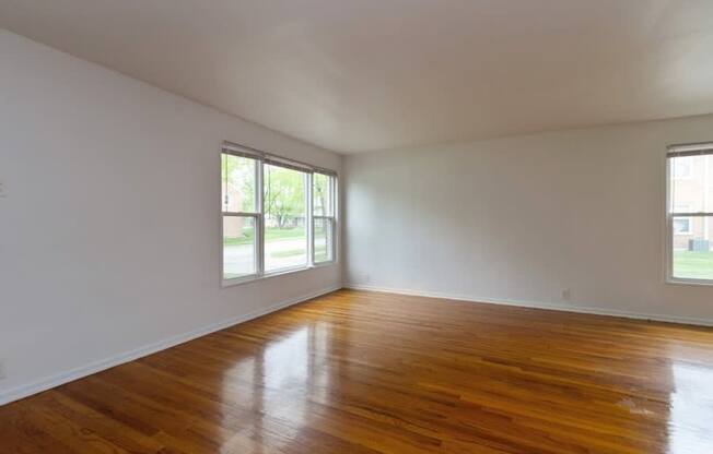 an empty living room with white walls and wood floors