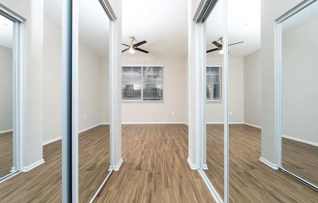 A room with wooden floors and a ceiling fan.