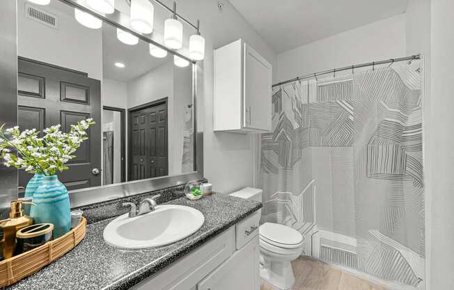 A bathroom with a white sink and a white toilet.