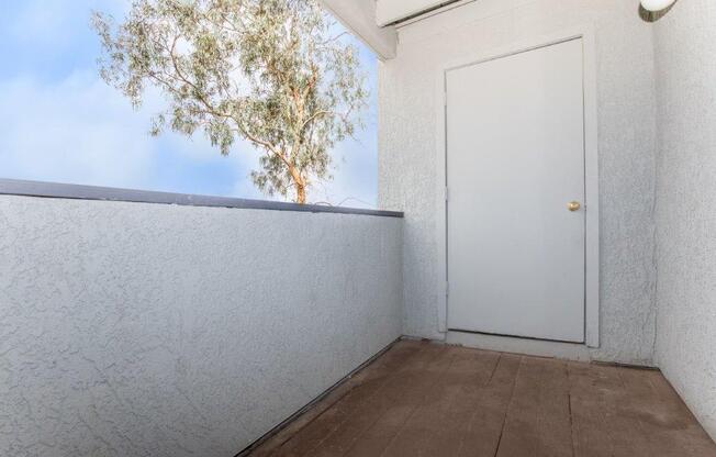 A white door is closed in a room with a brown floor.