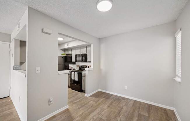 A kitchen area with a refrigerator, sink, and cabinets.
