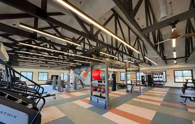 A gym with a variety of equipment including treadmills, weights, and exercise machines.