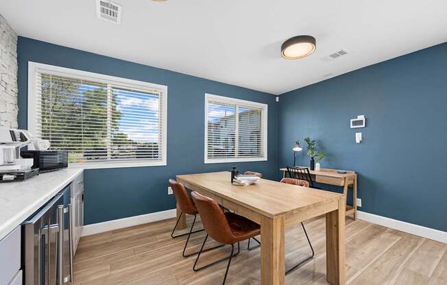 A kitchen with a table and chairs.