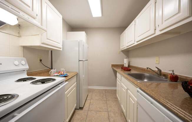 A kitchen with white cabinets and a stove top oven.