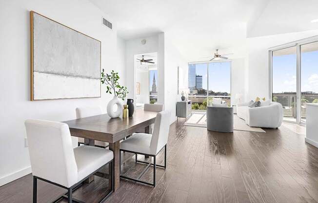 A modern dining room with a wooden table and white chairs.